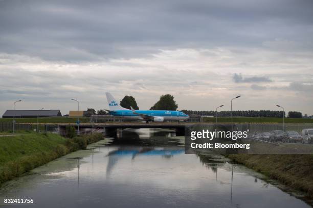 Passenger aircraft operated by KLM, the Dutch arm of Air France-KLM Group, crosses a bridge after landing at Schiphol airport in Amsterdam,...