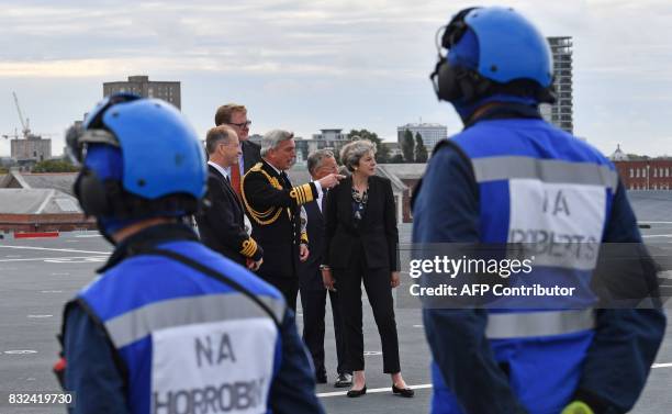 Britain's Prime Minister Theresa May talks with First Sea Lord Admiral Philip Jones as she tours the 65,000-tonne British aircraft carrier HMS Queen...