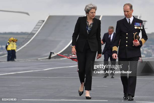 Britain's Prime Minister Theresa May talks with Commodore Jerry Kyd , Captain of the 65,000-tonne British aircraft carrier HMS Queen Elizabeth,...
