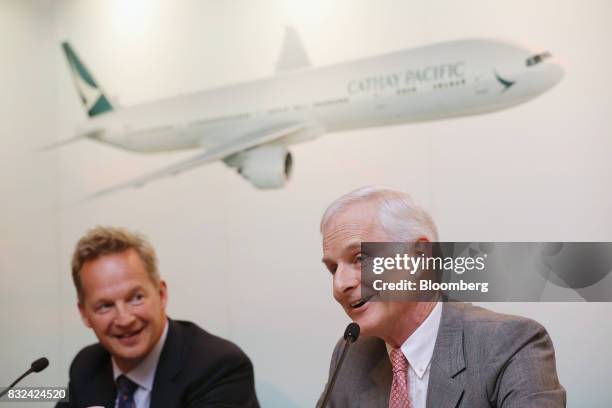 John Slosar, chairman of Cathay Pacific Airways Ltd., right, speaks as Rupert Hogg, chief executive officer, looks on during a news conference in...