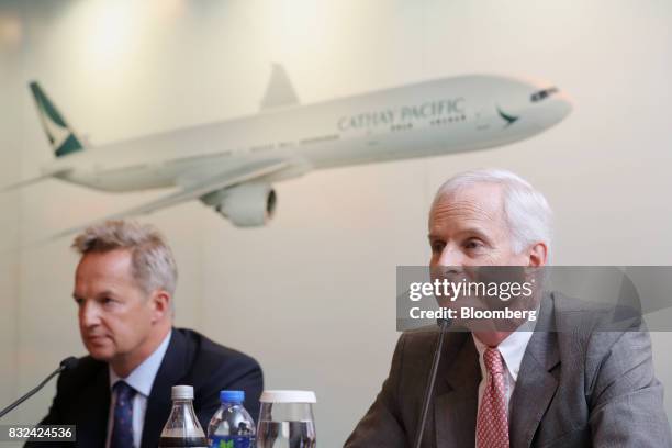 John Slosar, chairman of Cathay Pacific Airways Ltd., right, and Rupert Hogg, chief executive officer, listen during a news conference in Hong Kong,...