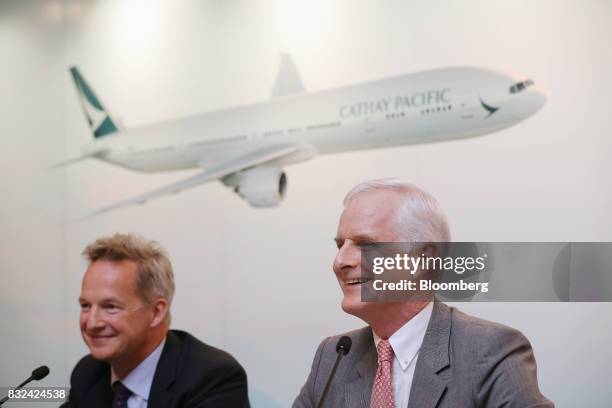 John Slosar, chairman of Cathay Pacific Airways Ltd., right, and Rupert Hogg, chief executive officer, react during a news conference in Hong Kong,...