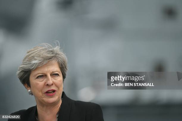 Britain's Prime Minister Theresa May stands on the flight deck as she speaks to crew members of the 65,000-tonne British aircraft carrier HMS Queen...