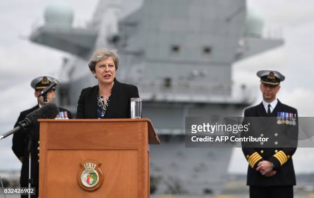 Commodore Jerry Kyd , listens as Britain's Prime Minister Theresa May stands on the flight deck and speaks to crew members of the 65,000-tonne...