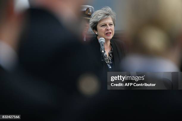 Britain's Prime Minister Theresa May stands on the flight deck as she speaks to crew members of the 65,000-tonne British aircraft carrier HMS Queen...