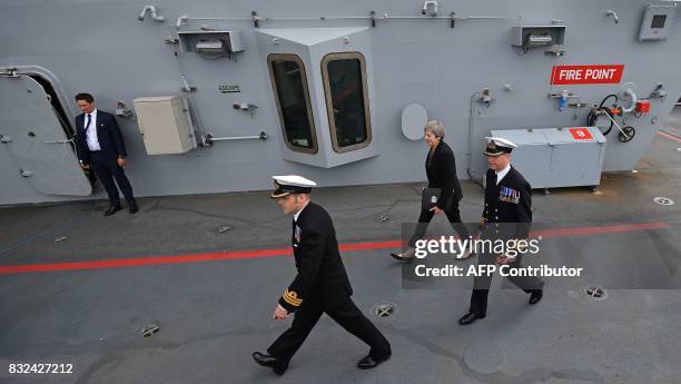 Commodore Jerry Kyd walks with Britain's Prime Minister Theresa May during her tour of the 65,000-tonne British aircraft carrier HMS Queen Elizabeth,...