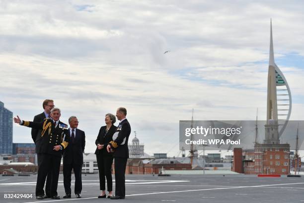 Britain's Prime Minister Theresa May talks with Commodore Jerry Kyd , Captain of the 65,000-tonne British aircraft carrier HMS Queen Elizabeth, and...