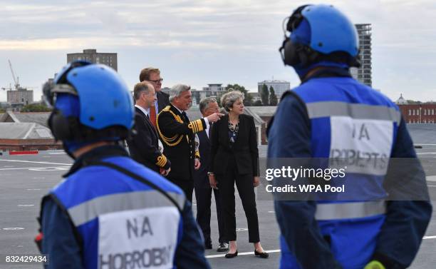 Britain's Prime Minister Theresa May talks with First Sea Lord Admiral Philip Jones as she tours the 65,000-tonne British aircraft carrier HMS Queen...