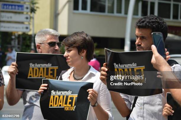 People hold placards that read 'There is no justice in this council' as anti-government demonstrators gathered in front of the Supreme Election...