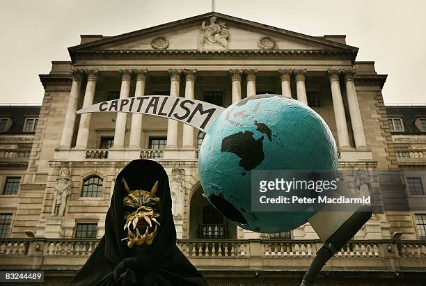 Grim reaper figure holds a globe pierced by the scythe of capitalism in front of the Bank of England during a protest on October 13, 2008 in London....