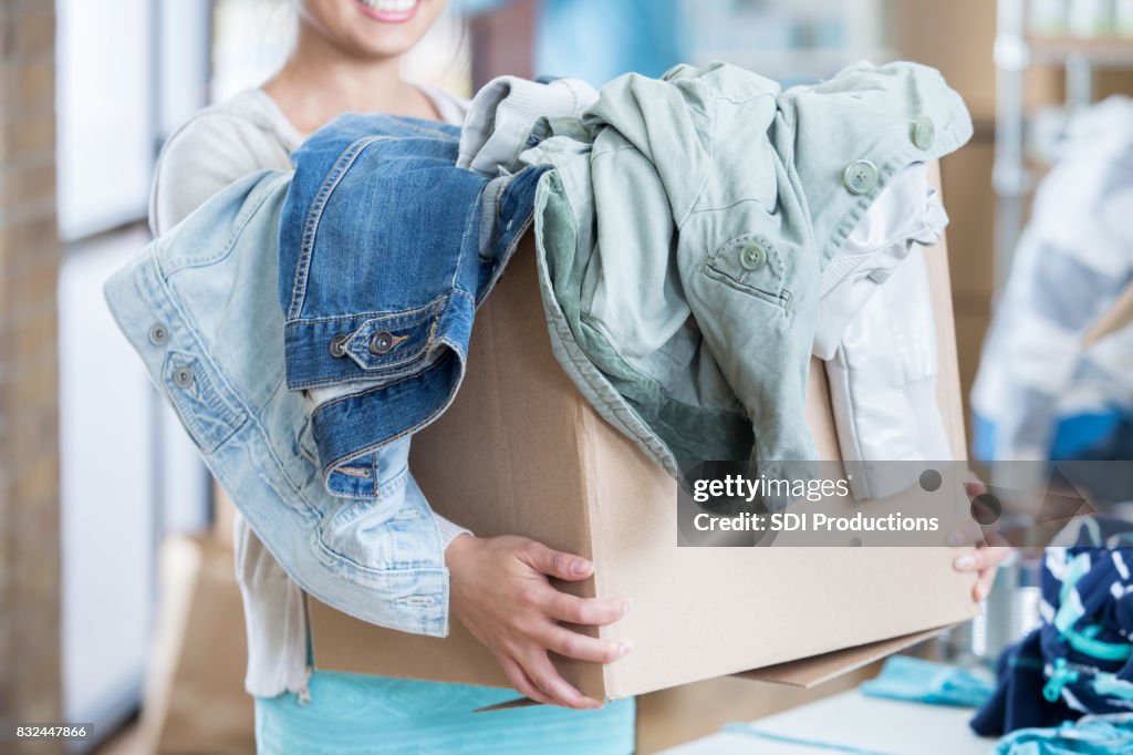 Nicht erkennbare Frau erhält Box von Kleidung während Kleidersammlung