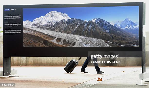 Man looks at a photo exhibit of the Himalayan mountains on October 8, 2008 at the World Conservation Congress in Barcelona. The photos, taken in the...