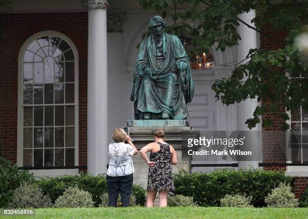 Two women take pictures in front of the statue of US Supreme Court Chief Justice Roger Brooke Taney that sits in front of the Maryland State House,...