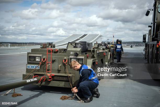 Navy crew members work on the deck of HMS Queen Elizabeth shortly after her arrival in Portsmouth Naval Docks on August 16, 2017 in Portsmouth,...