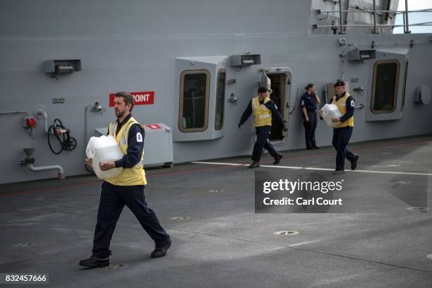 Navy crew members work on the deck of HMS Queen Elizabeth shortly after her arrival in Portsmouth Naval Docks on August 16, 2017 in Portsmouth,...