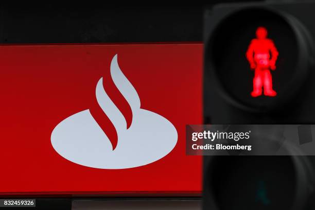 Pedestrian traffic light displays a red man outside a bank branch of Banco Santander SA in London, U.K., on Tuesday, Aug. 15, 2017. Banco Santander,...