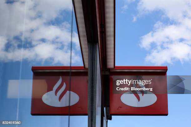 Window reflects signage outside a bank branch of Banco Santander SA in London, U.K., on Tuesday, Aug. 15, 2017. Banco Santander, Spains biggest...