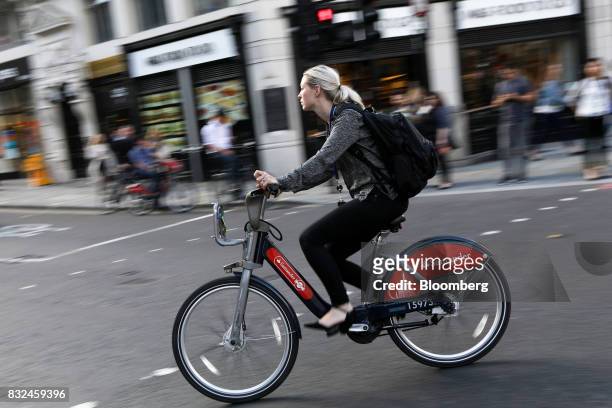 Cyclist rides a hired bicycle displaying logos of sponsor Banco Santander SA in London, U.K., on Tuesday, Aug. 15, 2017. Banco Santander, Spains...