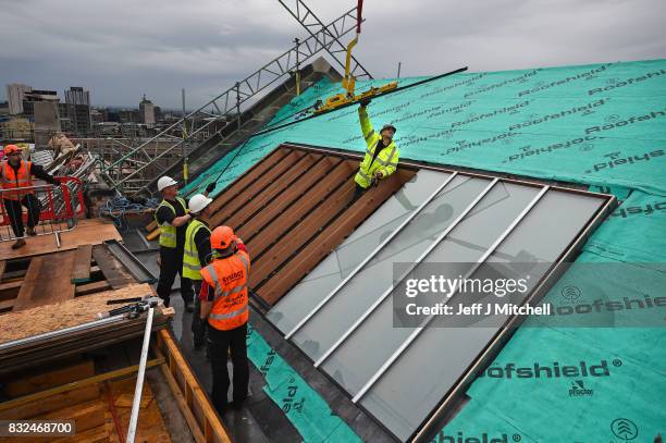 Workmen place glass windows into the iconic Japanese inspired studio 58 in Glasgow School of Art which is located two floor above the library in the...