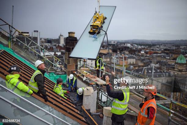 Workmen place glass windows into the iconic Japanese inspired studio 58 in Glasgow School of Art which is located two floor above the library in the...