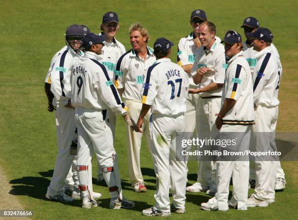 Shane Warne of Hampshire is congratulated by his team-mates after getting his sixth wicket of the second innings during the County Championship match...