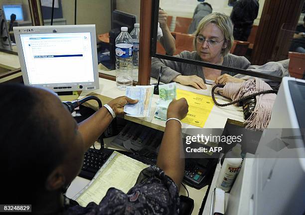 Une employée du Crédit Municipal remet de l'argent à une personne ayant déposé des objets de valeur à l'établissement, le 13 octobre 2008 à Paris....