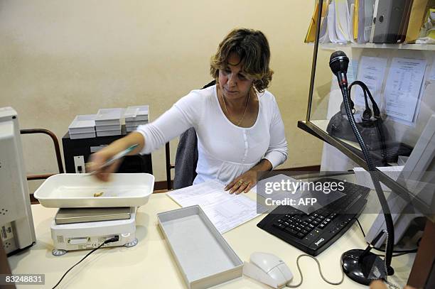 Une employée du Crédit Municipal pèse des bijoux en vue de leur estimation, le 13 octobre 2008 à Paris. Seule banque qui accorde des prêts à des...