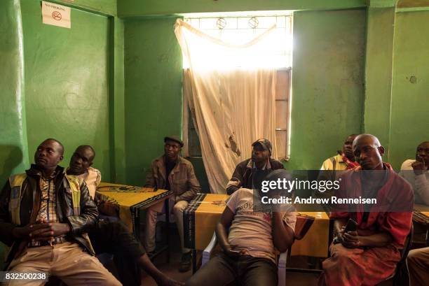 Men watch opposition candidate Raila Odinga speak at a press conference in a bar in the Mathare North neighborhood, on August 16, 2017 in Nairobi,...