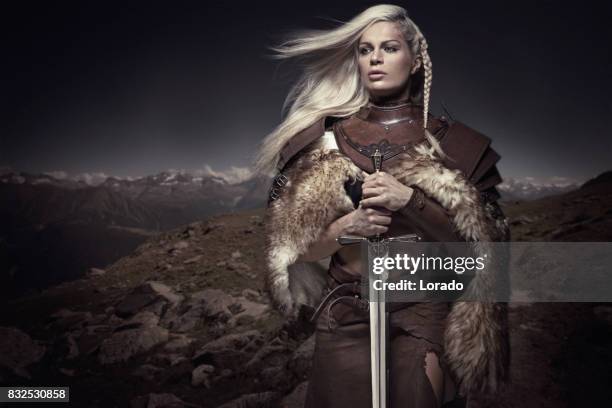 hermosa rubia espada empuñando vikingo guerrero mujer - vikings fotografías e imágenes de stock