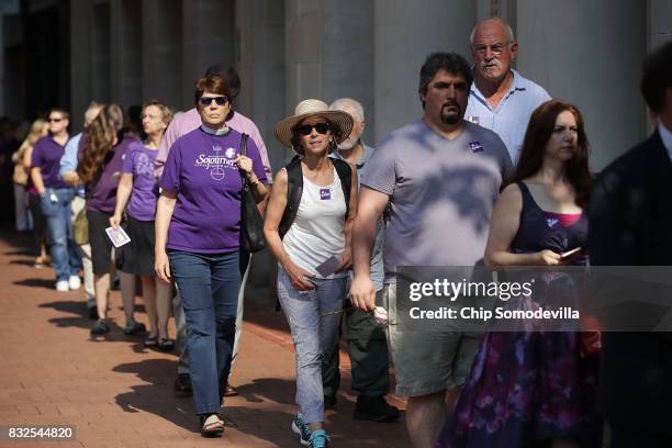 People line up to attend the memorial service for Heather Heyer, who was killed when a car slammed into a crowd of people protesting against a white...