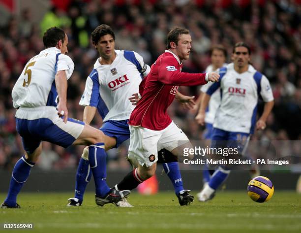 Manchester United's Wayne Rooney gets away from Portsmouth's Dejan Stefanovic and Andrew O'Brien