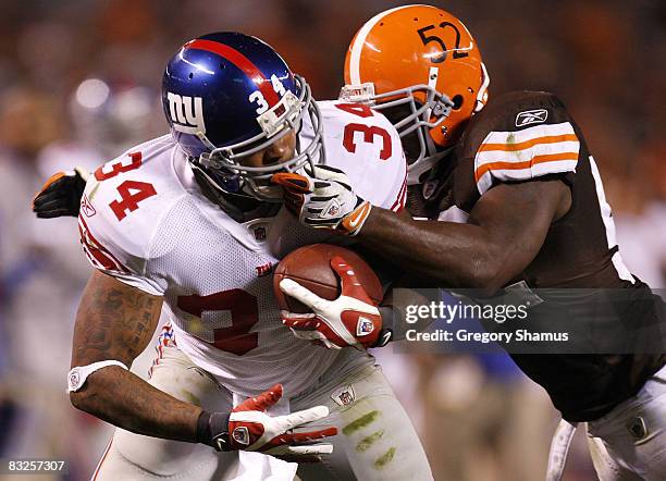 Derrick Ward of the New York Giants gets pulled down by the face mask by D'Qwell Jackson of the Cleveland Browns on October 13, 2008 at Cleveland...