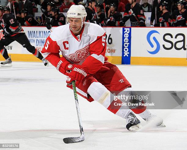 Nicklas Lidstrom of the Detroit Red Wings turns up ice with the puck during a NHL game against the Carolina Hurricanes on October 13, 2008 at RBC...