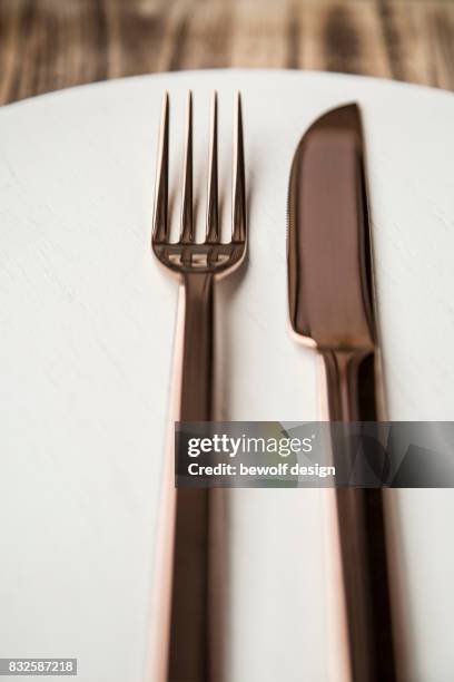 copper colored cutlery on white wooden board - besteck stock pictures, royalty-free photos & images