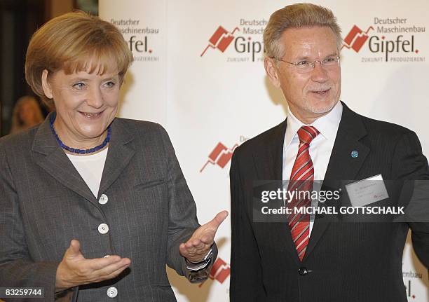 The president of the VDMA Manfred Wittenstein greets German Chancellor Angela Merkel before she delivers a speech at the third German engineering and...