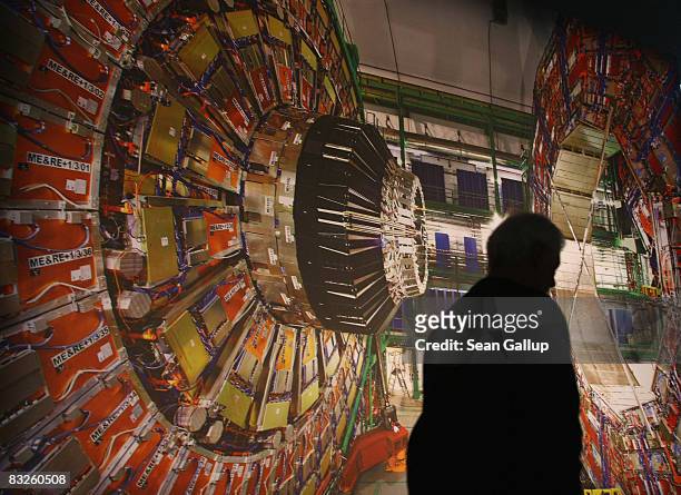 Worker walks past a giant photograph of the CMS detector of the Large Hadron Collider at the "Weltmaschine " exhibition on October 14, 2008 in...