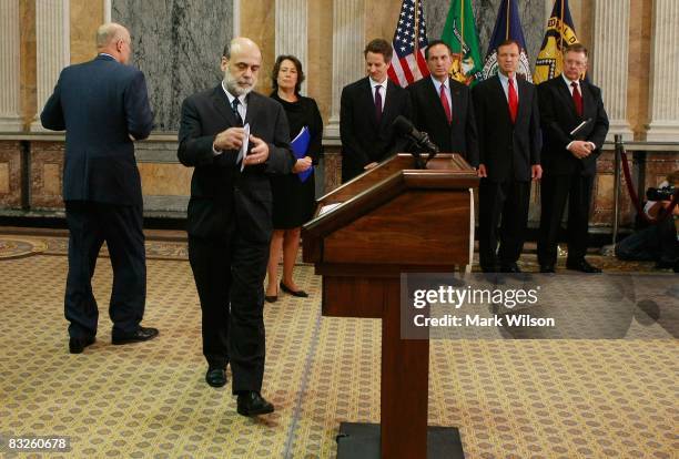 Secretary Henry M. Paulson walks aways as Federal Reserve Chairman Ben Bernanke walks up to speak while flanked by Federal Deposit Insurance Corp...