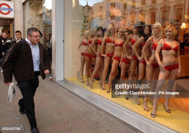 Member of the public walks past the ten finalists in the FHM 'High Street Honey 2006' competition from left to right: Charlie Taylor Charlotte...