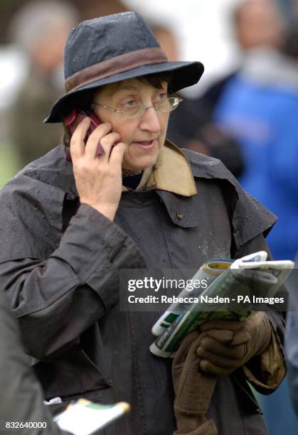 Trainer Henrietta Knight talks on a mobile phone in the parade ring at Plumpton Racecourse, East Sussex.