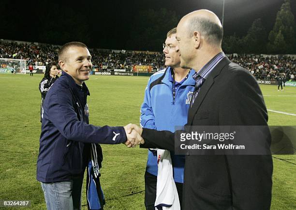 Owner Jon Fisher and President Mike Crowley of the San Jose Earthquakes shake hands with Executive Director Paul Barber of the Tottenham Hotspurs...