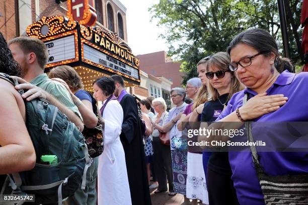 Clergy observe a moment of silence during the memorial service for Heather Heyer outside the Paramount Theater August 16, 2017 in Charlottesville,...