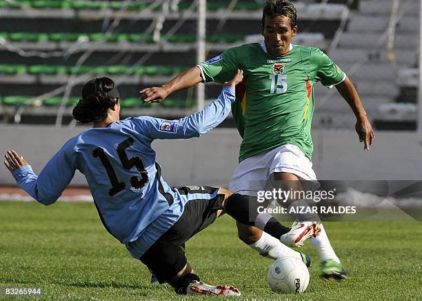Jaime Robles of Bolivia vies for the ball with Alvaro Gonzalez of Uruguay on October 14, 2008 at the Hernando Siles stadium in La Paz, during their...