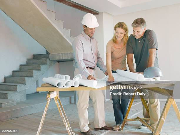 construction foreman explaining blueprints to couple - real estate developer 個照片及圖片檔