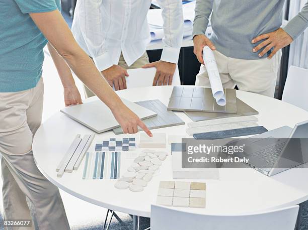 interior designer talking with couple in showroom - property developer stock pictures, royalty-free photos & images