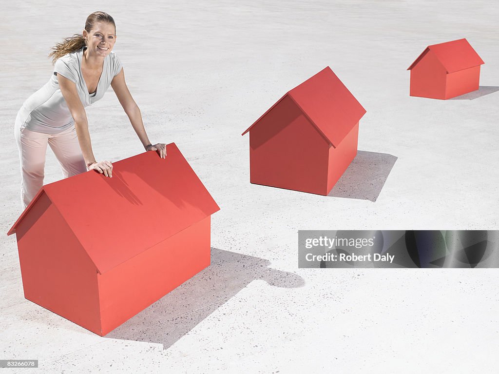 Woman leaning over model houses