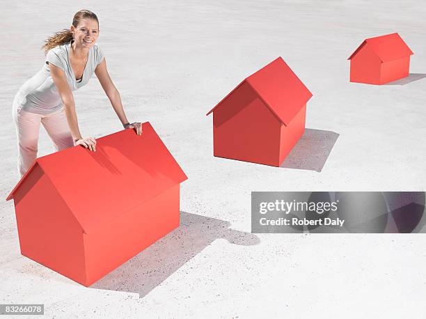 woman leaning over model houses - housing development south africa stock pictures, royalty-free photos & images