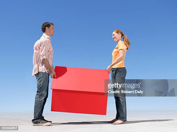 couple holding small model house - bridging the gap stock pictures, royalty-free photos & images
