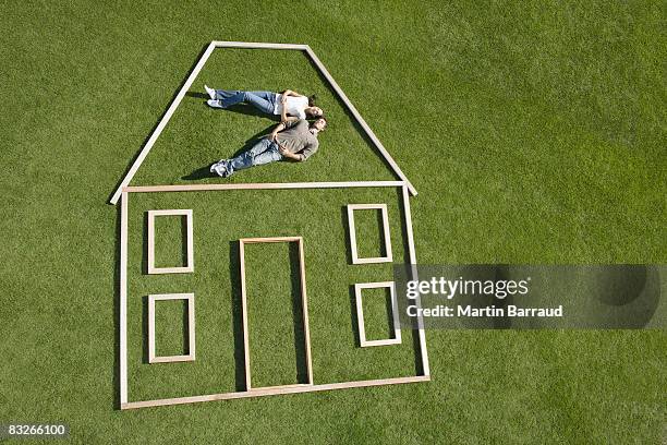 couple laying inside house outline - dreaming of home ownership stock pictures, royalty-free photos & images