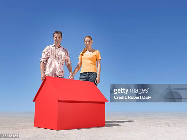 casal em pé com pequena casa modelo em deserto - desert house day 2 imagens e fotografias de stock