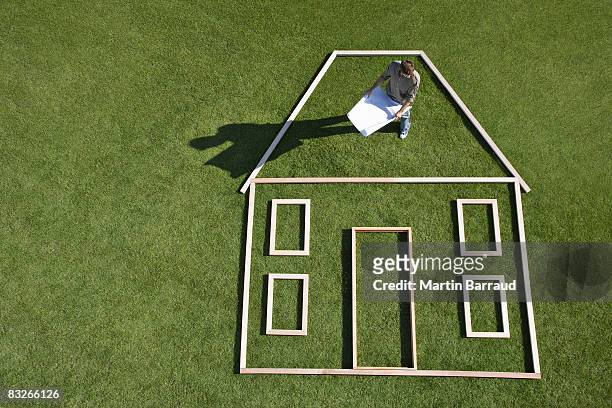 architect with blueprints standing inside house outline - life drawing model stock pictures, royalty-free photos & images